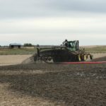 manure being surface applied prior to corn planting